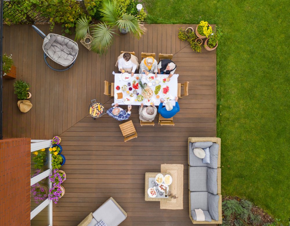 Group of older friends sitting by the table at the party at the terrace